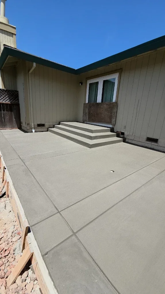 Concrete patio meeting a raised porch and steps